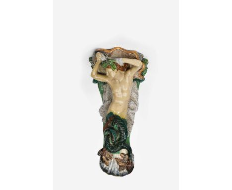 A large Minton majolica wall bracket, modelled as a merman, below a large conch shell, before green waves and fishing nets, g