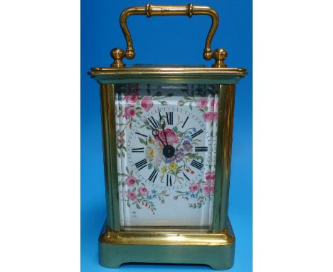 A 19th century brass carriage clock with swan neck swing handle, ogee side columns and cutaway plinth base, the white enamel 