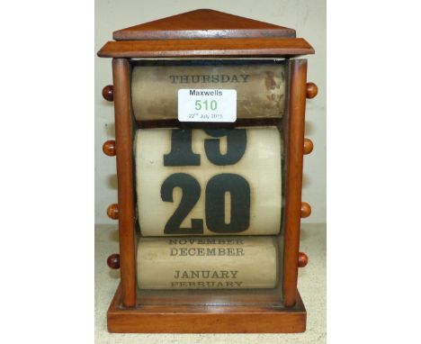 A vintage roller calendar in stained wood architectural case, height 9"