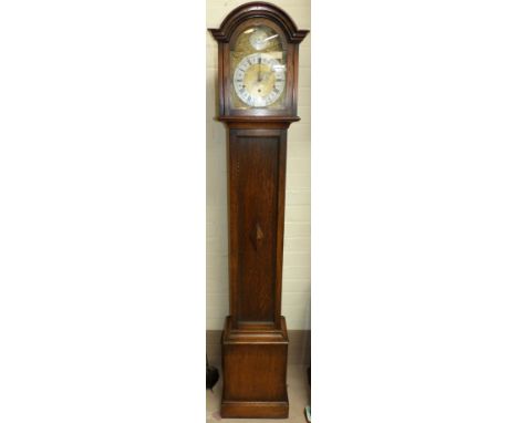 A 1930's oak arch top longcase clock with brass dial and chiming spring driven movement