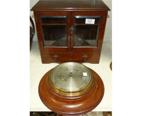 A small oak smoker’s cabinet and an aneroid barometer
