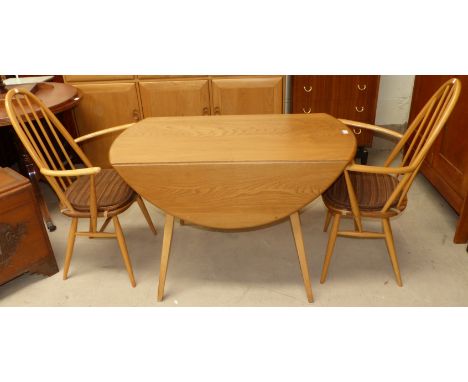 An Ercol light elm drop leaf dining table; a stick back carver and dining chair