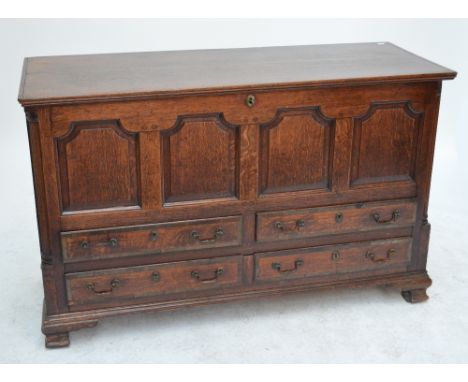 A 19th century oak Lancashire mule chest, with shaped fielded panels to the front, flanked by reeded pilasters above four dra