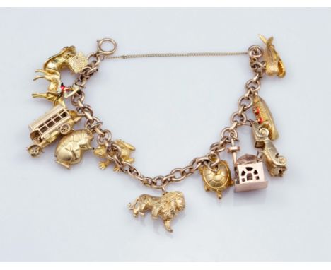 A 9ct yellow gold charm bracelet suspending eleven predominantly 9ct gold charms including Jonah and the whale, a frog, a tur