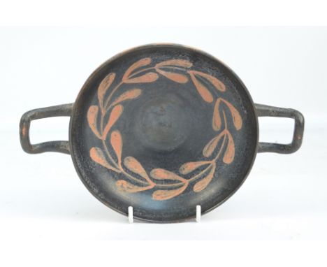 A Greek campanian kylix decorated to the inside and out with a band of stylised leaves, c.335 B.C., width 24cm.   CONDITION R