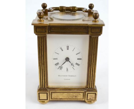 MATTHEW NORMAN; a brass carriage clock of small proportions with swing loop handle, reeded pilasters and Roman numerals to th