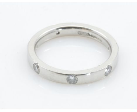 A platinum and diamond eternity ring, set with seven equally spaced stones, size K, approx 5.2g.