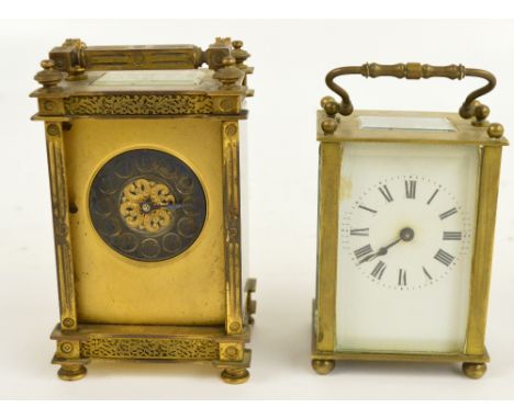 A late 19th/early 20th century French gilt carriage clock with fluted corners and pierced foliate scroll decorated top and bo