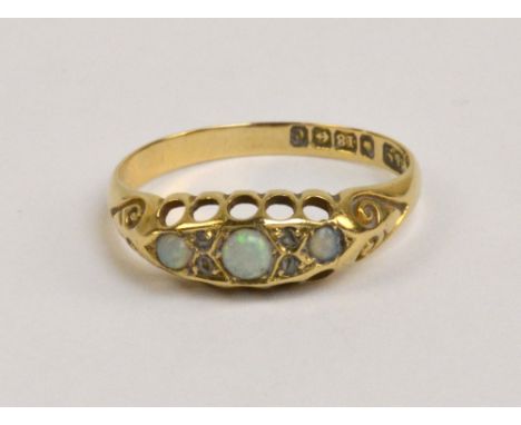 An 18ct yellow gold three stone opal ring, the central opal flanked by melee diamonds, size O 1/2, approx 2.6g.