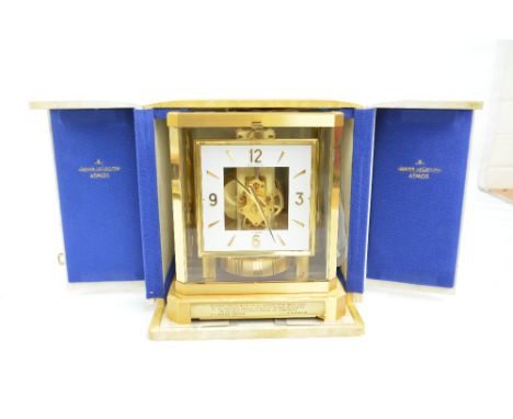JAEGER-LECOULTRE; a boxed 'Atmos' gilt brass framed mantel clock with square chapter ring set with Arabic and baton numerals,