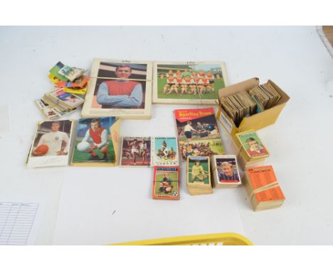 A quantity of football trading cards, Typhoo Tea team photographs, and a Manchester United FC enamel badge.