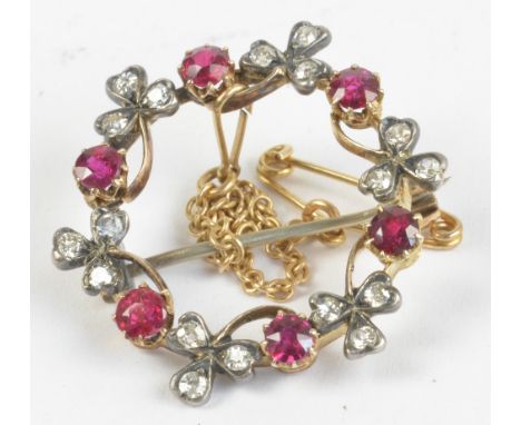A yellow metal ruby and diamond circular pierced floral decorated brooch with safety link chain, diameter approx 2.6cm, appro