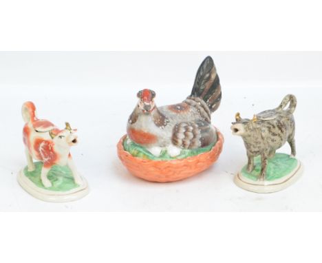 A 19th century Staffordshire cow creamer on gilt heightened oval base, with grey and black mottled decoration, length 17cm, a