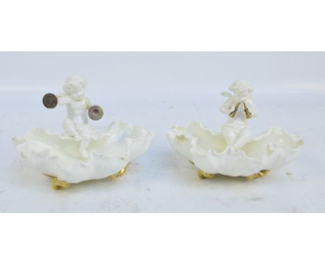 MOORE BROS; a pair of cherubic set shaped bowls, one playing the symbols, one the pipes, width 17cm.   CONDITION REPORT:  rim