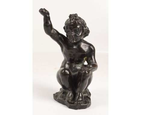 A 19th century bronze figure of a seated cherub with his hand raised, possibly a base of a candlestick or part of a clock gar