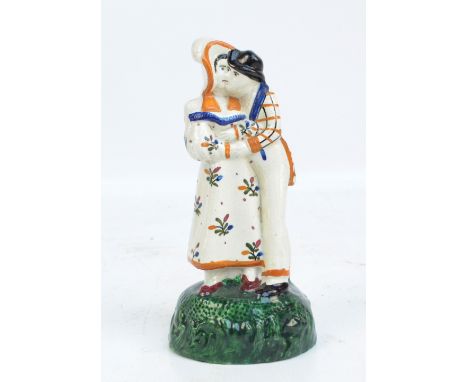 An early 19th century Prattware figure group 'Lovers', bearing traces of paper label to base, height 14cm.