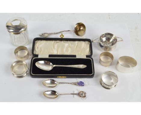 A group of silver items including two bonbon dishes, a cased spoon, tea strainer and stand, toilet jar with silver cover, two