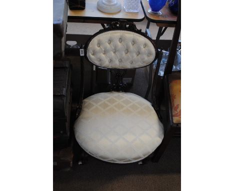 A Victorian mahogany framed oval button back side chair with carved decoration and pierced splat support on turned front legs