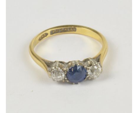 An 18ct yellow gold three stone ring set with central blue spinel flanked by diamonds in claw setting, size K, approx 2.7g.  