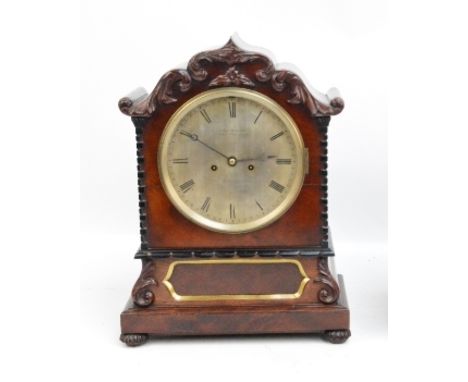 An early Victorian mahogany bracket clock with shaped carved case, 'Brick' pilasters and circular silvered dial inscribed 'Wi