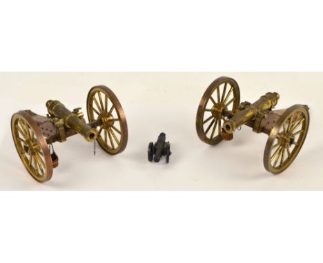 A pair of brass and wooden model cannon, length 20cm and a small modern cannon (3).