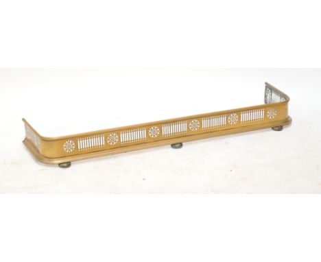 A pierced brass fender on bun feet, length 120cm and a quantity of other brass items including two companion sets, andirons, 