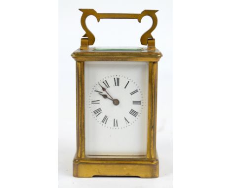 An early 20th century brass cased carriage clock, with swing loop handle above rectangular white enamel dial set with Roman n