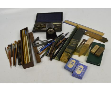 A collection of rulers, folding rules, slide rules, paint brushes, pencil sharpener, compass and other drawing instruments an