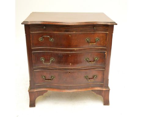 A late 19th century mahogany serpentine chest of drawers, the crossbanded top above a brushing slide and three long drawers o