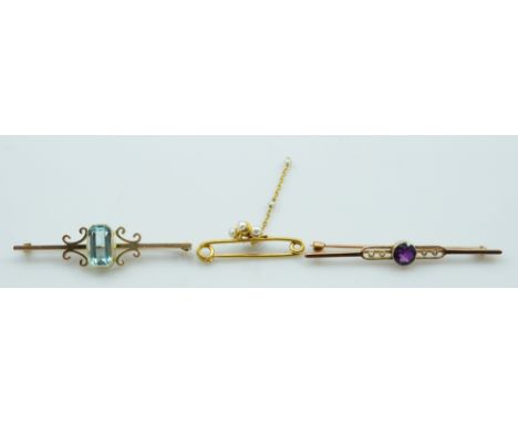 A 9ct yellow gold bar brooch set with a faceted amethyst, with two seed pearl halves either side on a pierced bar, a 9ct yell