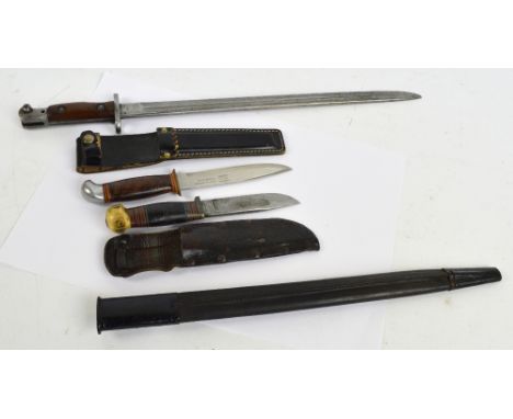 A 1907 Sanderson SMLE bayonet in scabbard, a Swedish Frosts carbon steel Bowie knife in sheath and a similar Finnish example 