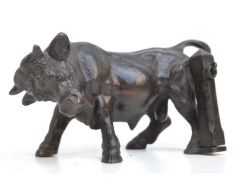 A small late 19th century bronze figure of a bull standing beside a post, unsigned, length 12cm.