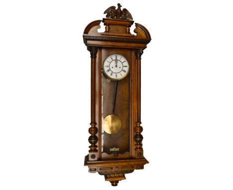 A late 19th century walnut twin weight Vienna wall clock, the two piece enamel dial set with Roman numerals and subsidiary se