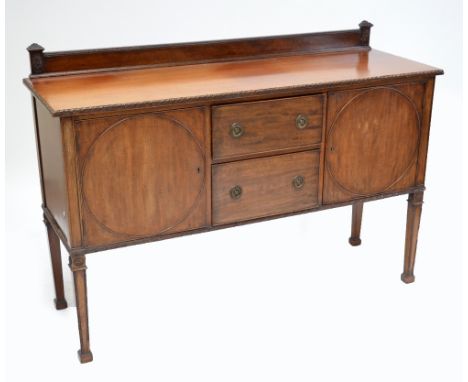An early 20th century mahogany sideboard, with raised gallery and two central drawers flanked by two hinged doors, with circu