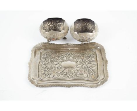 An Eastern white metal small tray, marked '90', with floral and foliate repoussé decoration, length 20cm, and a pair of India
