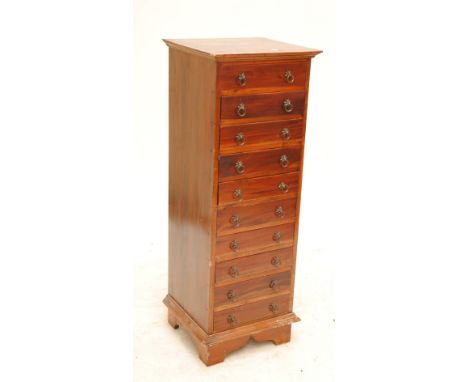 A tall narrow chest of nine drawers on bracket feet, top 46 x 42cm, height 124cm.