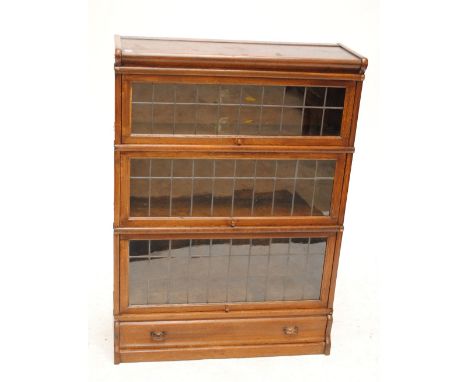 A Globe Wernicke three tier oak bookcase, each tier with leaded glazed up and over front with Globe Wernicke sticker to the i