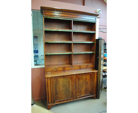 A large early 19th century mahogany bookcase, the moulded cornice above arrangement of open shelves with leather tabs and thr