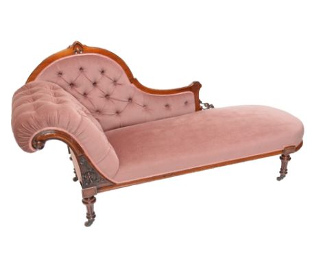 A Victorian walnut framed and button upholstered chaise longue raised on ring turned fluted legs.