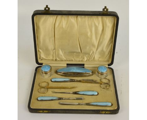 LIONEL SMITH & CO; a cased George V hallmarked silver and blue guilloche enamel mounted manicure set including two silver top