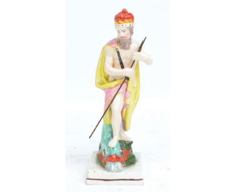 An early 19th century Staffordshire figure of Neptune, modelled standing upon a stylised dolphin with square section base, he