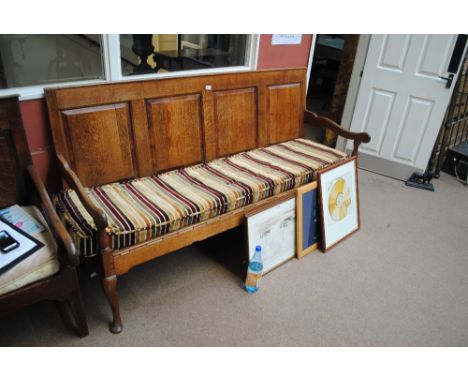 A 19th century oak settle, with four panel back and rope strung seat with velvet cushion, on front cabriole legs, length 183c