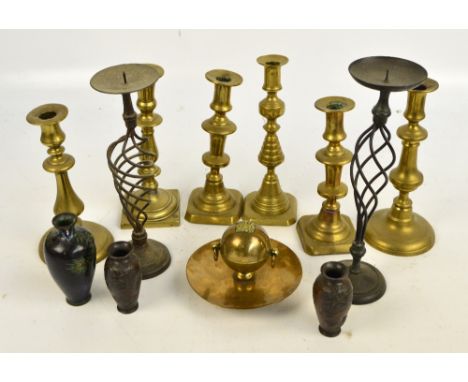 Six various brass candlesticks, a pair of wirework pricket examples and a copper and brass inkwell attached to a circular tra
