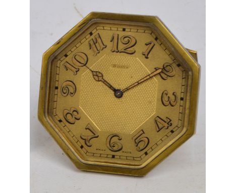 A 1930s Art Deco brass framed easel backed eight day travelling clock with octagonal case and Arabic numerals to the dial, he