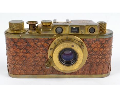 A gilt metal cased snake skin decorated camera inscribed 'Leica, no 258544', in leather case.