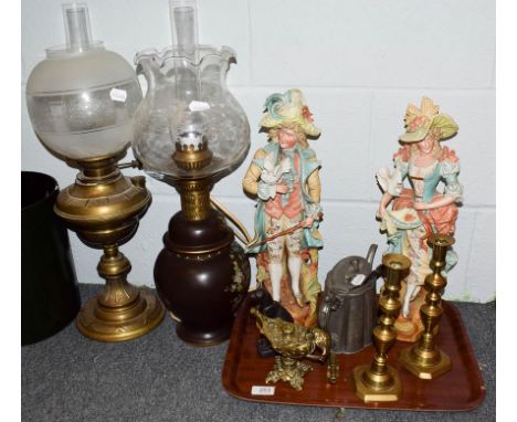 A pair of coloured bisque figures, two oil lamps, painted lacquer bucket, Romanesque oil lamp and other metal wares