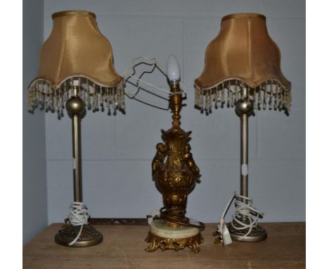 A pair of modern silvered table lamps together with a gilt metal and onyx table lamp of urn form surmounted by putti (3)