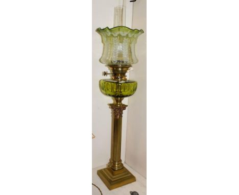 A Victorian brass based oil lamp, raised on a fluted Corinthian column base, with Messenger's No.2 burner and having green gl