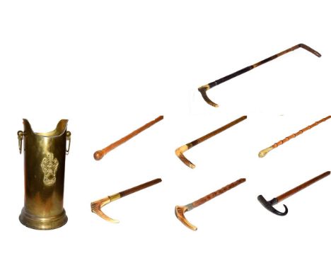 ~ A brass stick stand with loop handles containing six walking sticks and a riding crop, including bamboo examples and with h