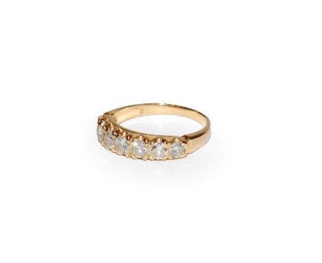 A diamond seven stone ring, the graduated round brilliant cut diamonds in yellow claw settings, to a tapered shoulder plain p